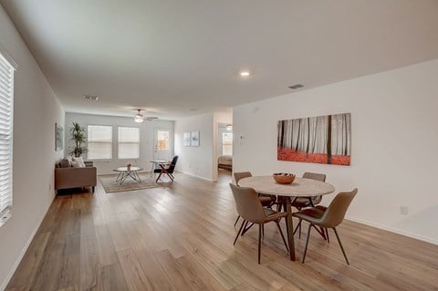 a dining room and living room with a table and chairs